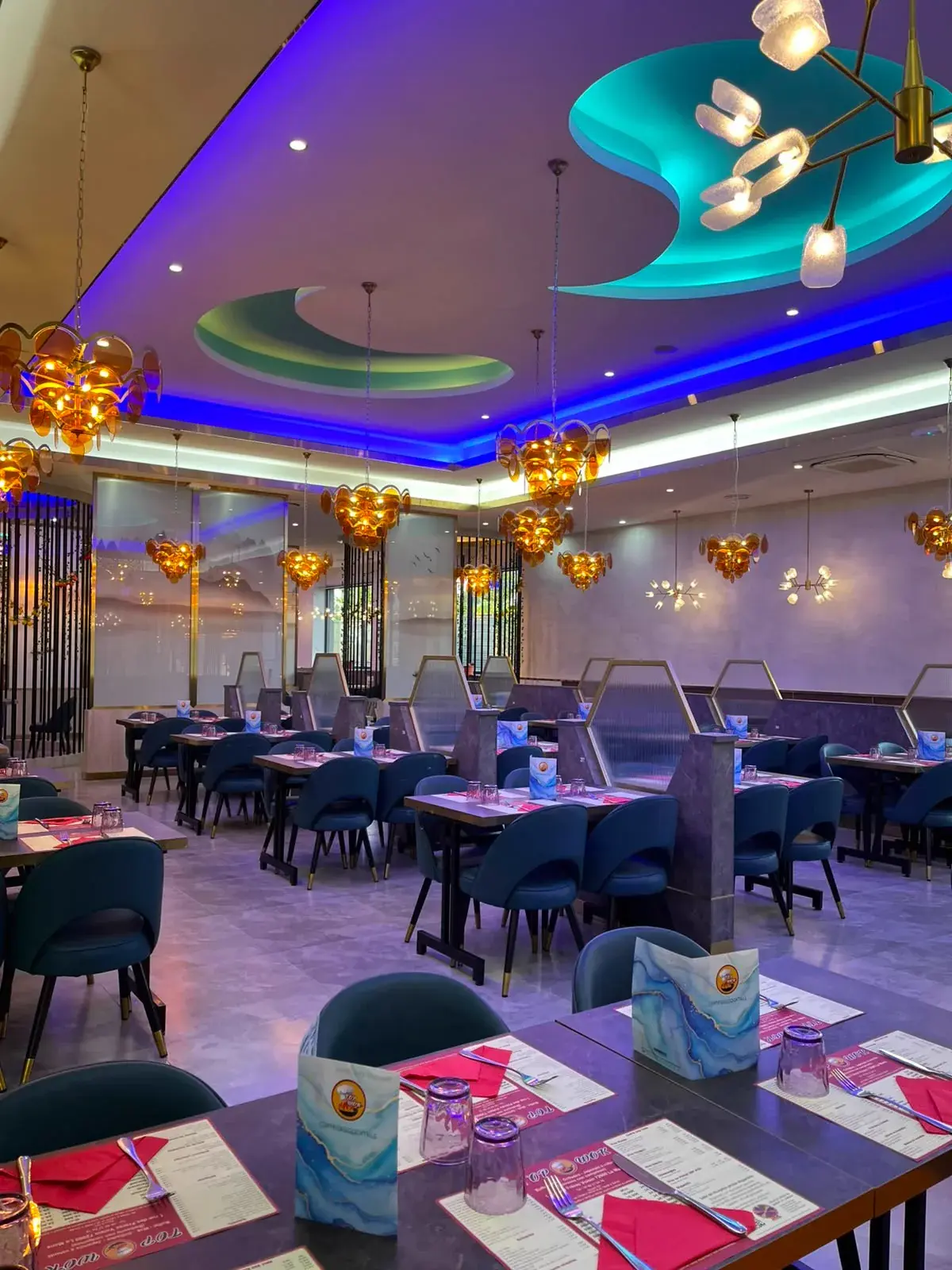 Salle de Top Wok avec ses chaises bleues et ses luminaires