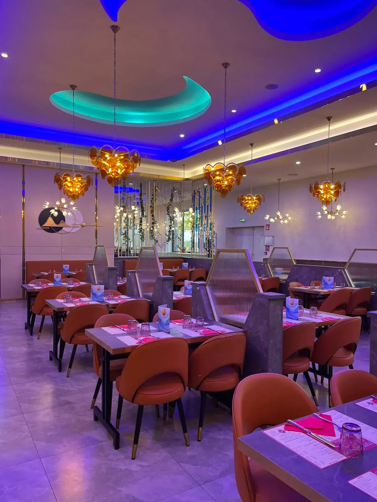 Salle de Top Wok avec ses chaises orange et son plafond lumineux