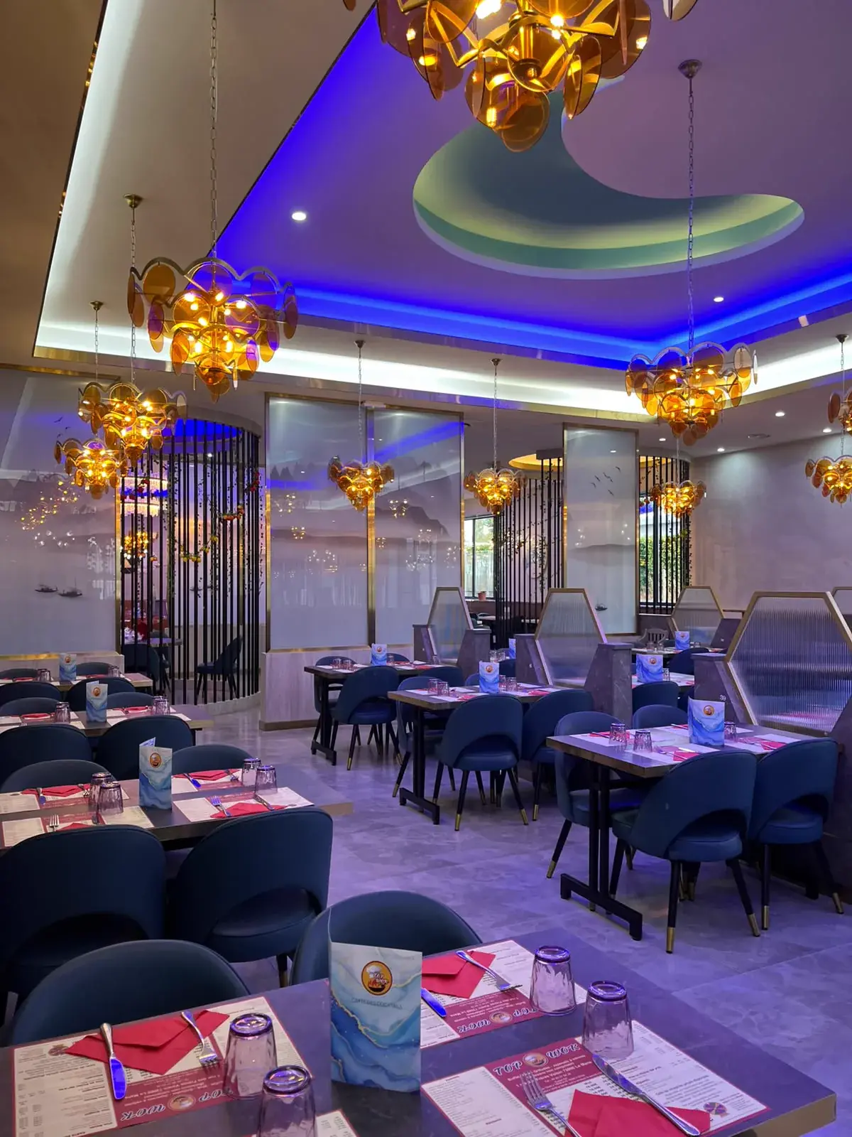 Tables dressées et chaises bleues dans la salle de Top Wok